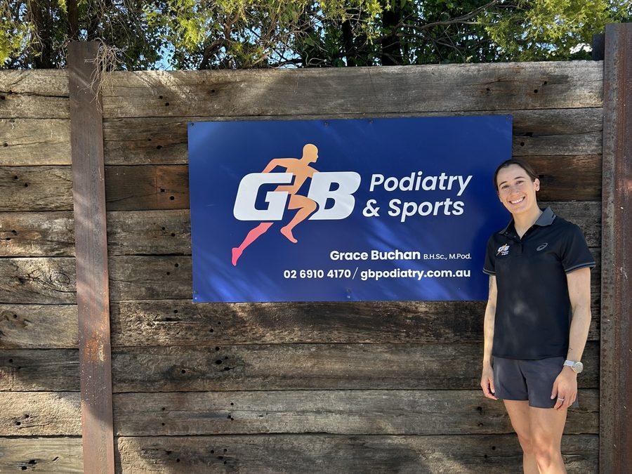 Grace Buchan next to the GB Podiatry and Sports clinic sign